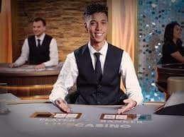 Tangan pengguna yang memegang ponsel dengan antarmuka belijitu menampilkan berbagai opsi hiburan sports dan casino